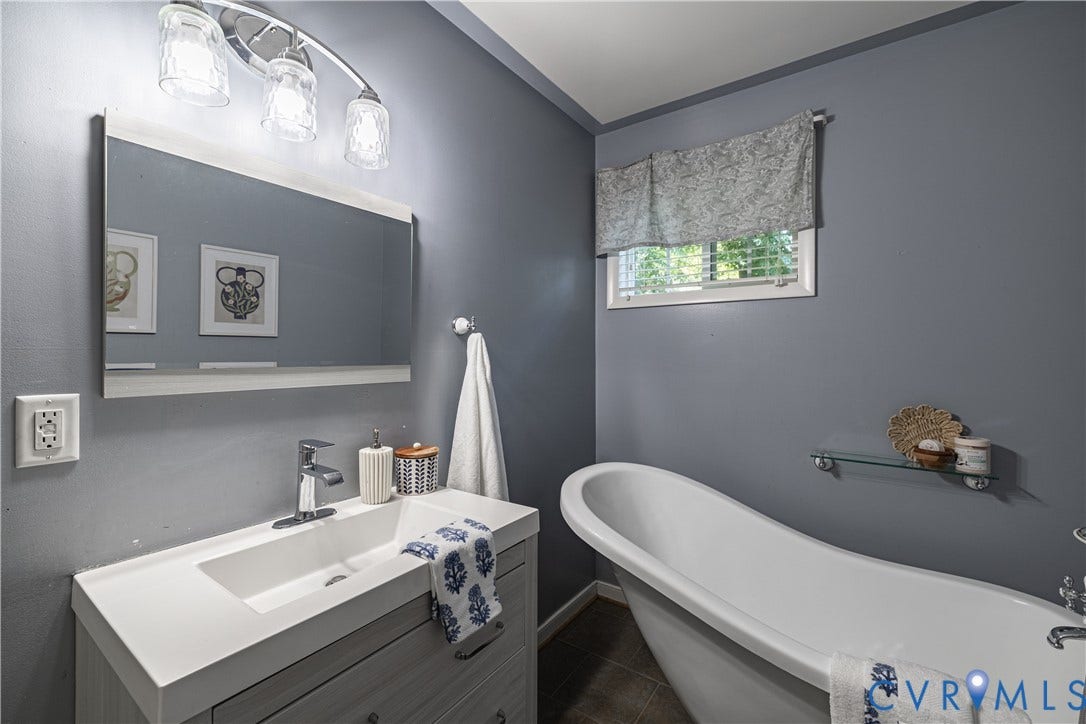 704 Forestview Drive, Colonial Heights, VA 23834 Bathroom featuring a freestanding soaking tub, wood-finish flooring, and a single vanity with integrated sink