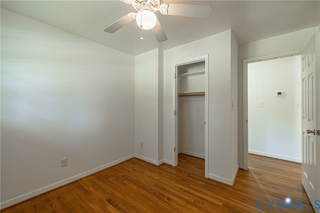 704 Forestview Drive, Colonial Heights, VA 23834 Bedroom featuring wood-finish flooring, a ceiling fan with integrated lighting, a built-in closet with shelving and hanging rod, and a white paneled door