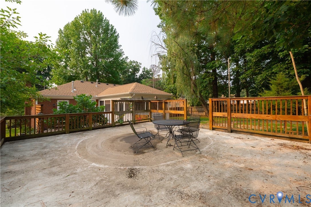 704 Forestview Drive, Colonial Heights, VA 23834 Spacious concrete patio area featuring a perimeter wood fence, wood railing, and surrounding mature trees