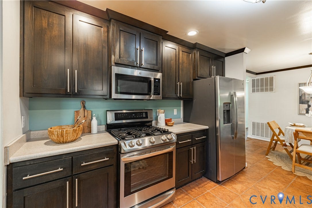 704 Forestview Drive, Colonial Heights, VA 23834 Kitchen featuring wood-finish cabinetry, stainless steel appliances, light-toned countertops, and a tile floor