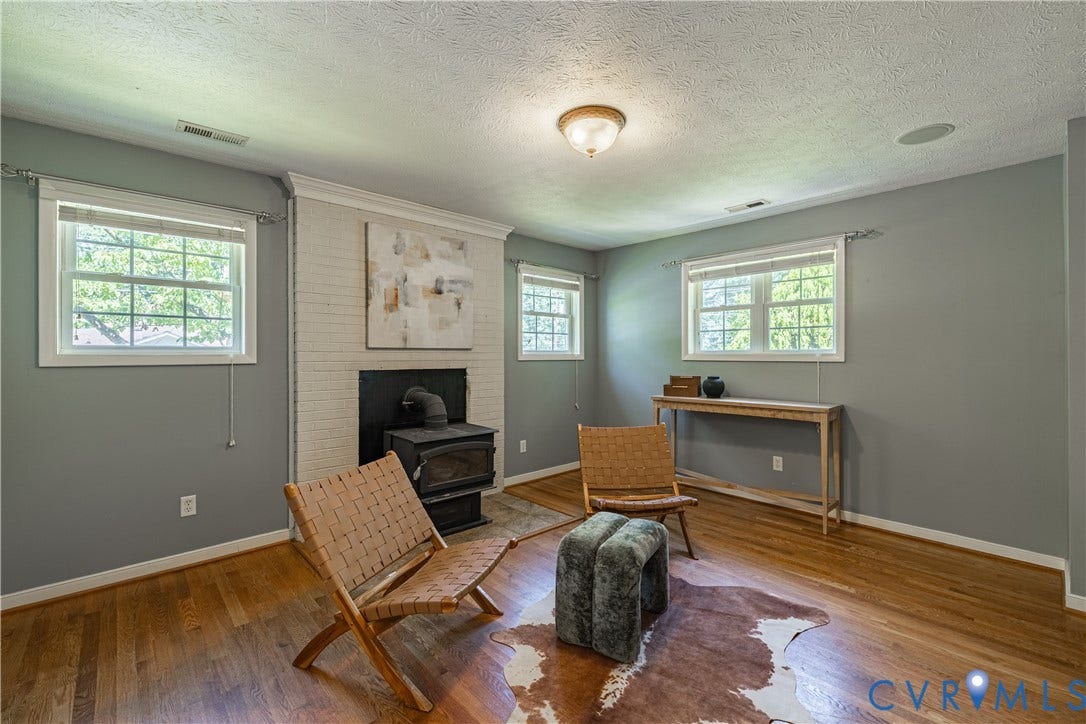 704 Forestview Drive, Colonial Heights, VA 23834 Wood-finish flooring throughout, featuring a white brick fireplace with a black wood-burning stove