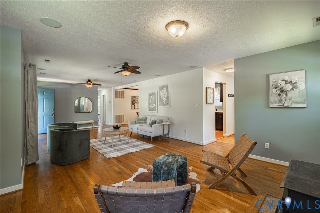 704 Forestview Drive, Colonial Heights, VA 23834 Spacious room featuring wood-finish flooring, light blue and white painted walls, recessed ceiling lighting, two ceiling fans with integrated lighting, and a light blue entry door