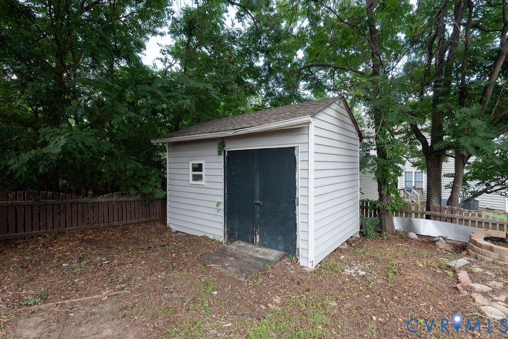 4924 Sadler Glen Ct, Sadler Glen, Glen Allen, VA 23060 Detached storage shed with light-colored siding, dark double doors, and a small window