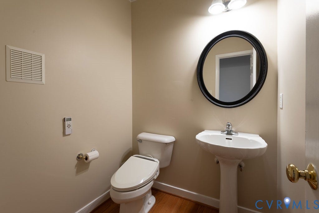 4924 Sadler Glen Ct, Sadler Glen, Glen Allen, VA 23060 Powder room featuring hardwood flooring, a pedestal sink, and a circular mirror with a decorative frame