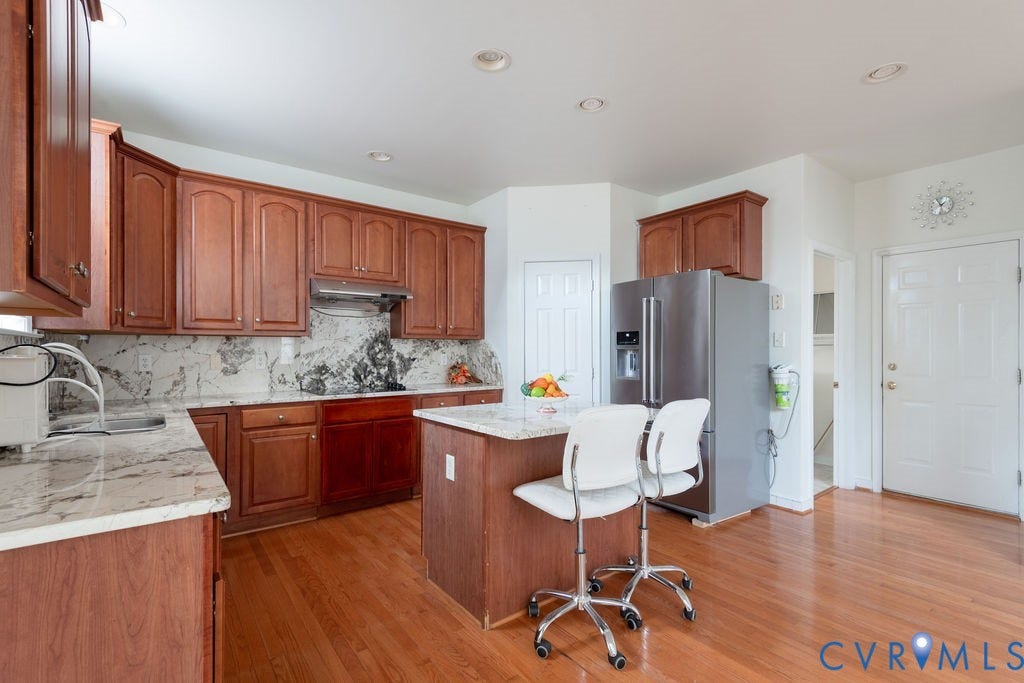 4924 Sadler Glen Ct, Sadler Glen, Glen Allen, VA 23060 Kitchen featuring wood-finish cabinetry, light-toned countertops, and a central island