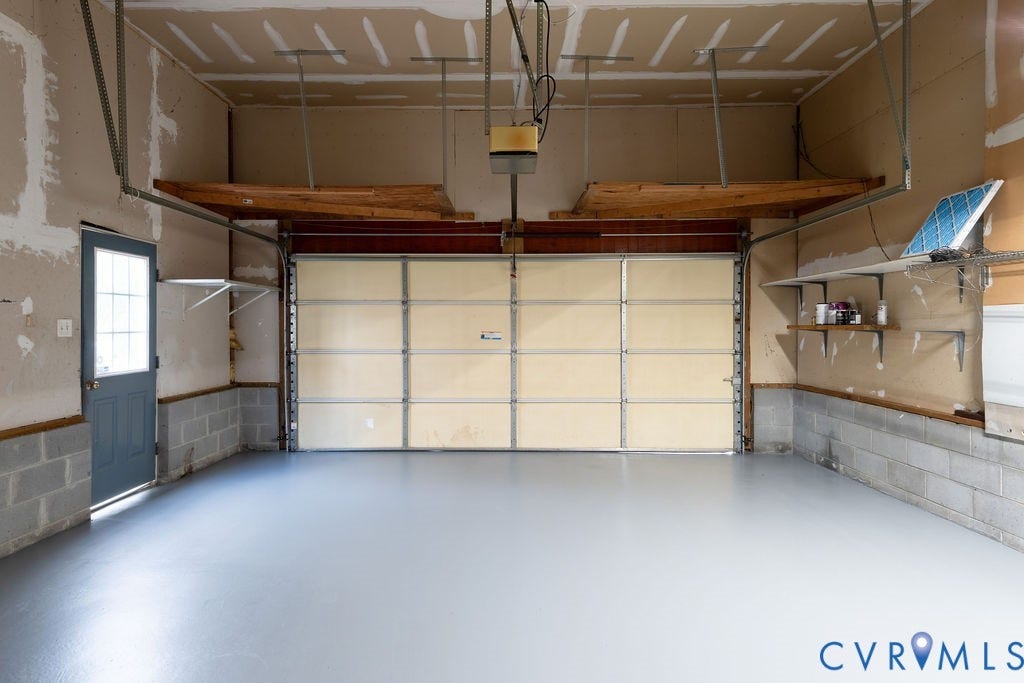 4924 Sadler Glen Ct, Sadler Glen, Glen Allen, VA 23060 Spacious garage featuring an overhead door, side entry door with window, and a gray-finished floor