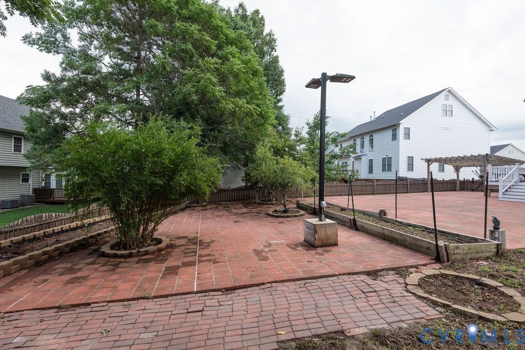 4924 Sadler Glen Ct, Sadler Glen, Glen Allen, VA 23060 Expansive brick paver patio featuring a central planting bed and perimeter raised garden beds