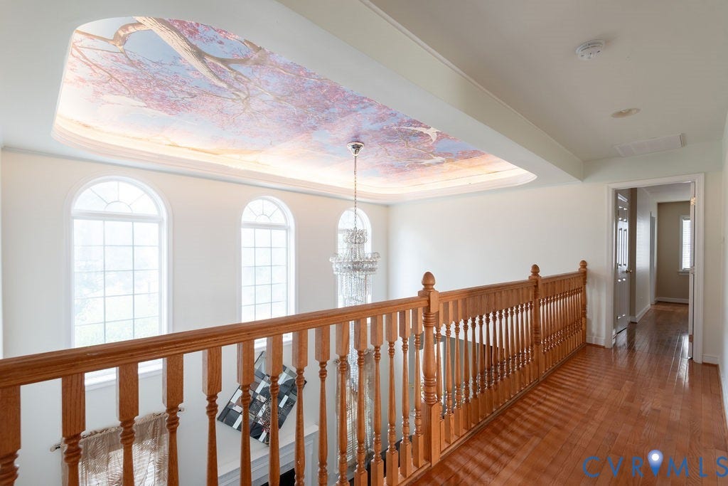 4924 Sadler Glen Ct, Sadler Glen, Glen Allen, VA 23060 Upper-level hallway featuring wood-finish flooring, a wood balustrade, and a decorative tray ceiling with a recessed chandelier