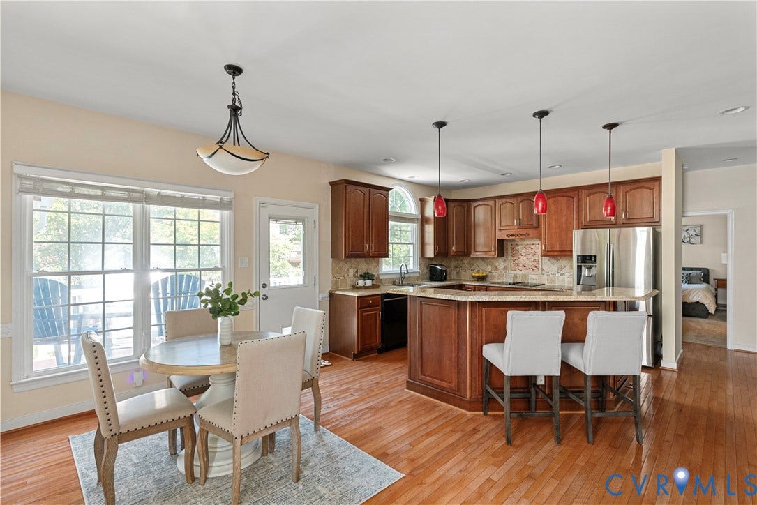 5009 Sadler Place Terrace, Glen Allen, VA 23060 Eat-in kitchen with hardwood flooring, wood cabinetry, stainless steel appliances, central island with bar seating, stone countertops