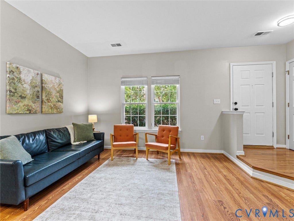 10100 Robin Lee Lane, Laurel Lakes, Glen Allen, VA 23060 Living area featuring wood-finish flooring, light grey wall paint, and a bright white entry door