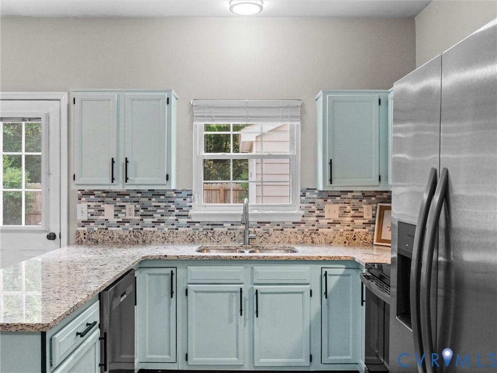 10100 Robin Lee Lane, Laurel Lakes, Glen Allen, VA 23060 Kitchen featuring light blue cabinetry, granite countertops, a stainless steel refrigerator, a multi-tone tile backsplash, and a window with a blind