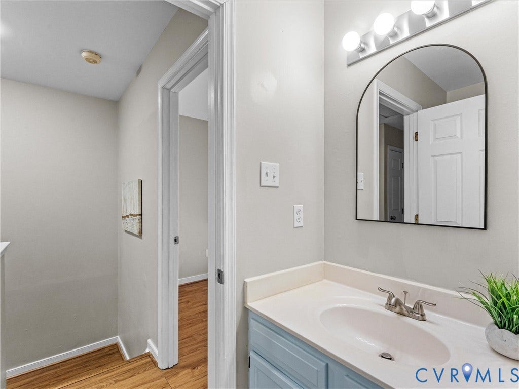 10100 Robin Lee Lane, Laurel Lakes, Glen Allen, VA 23060 Bathroom vanity with a light blue base, a light-toned countertop, and an integrated sink with a brushed nickel faucet
