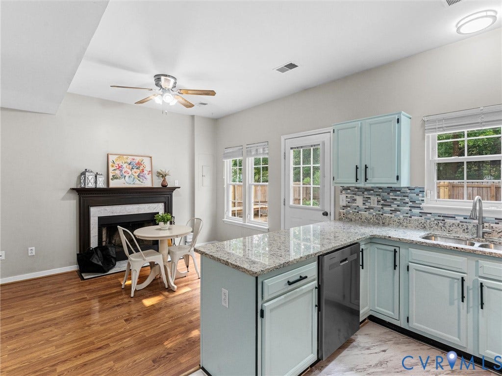 10100 Robin Lee Lane, Laurel Lakes, Glen Allen, VA 23060 Kitchen and living space featuring blue cabinetry, granite countertops, a tile backsplash, and a fireplace with a dark wood mantel