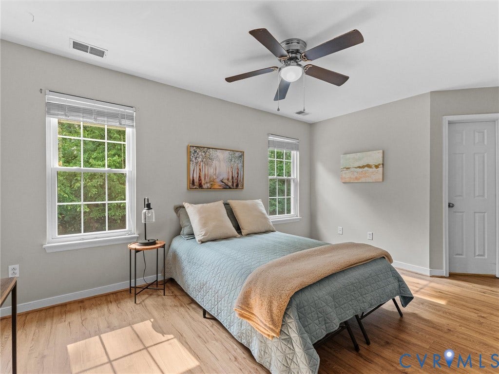 10100 Robin Lee Lane, Laurel Lakes, Glen Allen, VA 23060 Bedroom featuring wood-finish flooring, two large windows with horizontal blinds, and a ceiling fan with integrated lighting