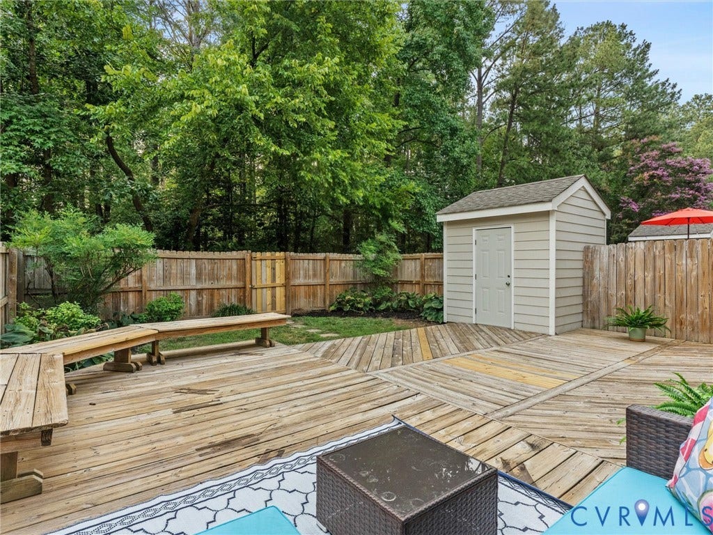 10100 Robin Lee Lane, Laurel Lakes, Glen Allen, VA 23060 Expansive backyard featuring a multi-level wood deck, privacy fencing, mature trees, a storage shed, and a built-in wooden bench