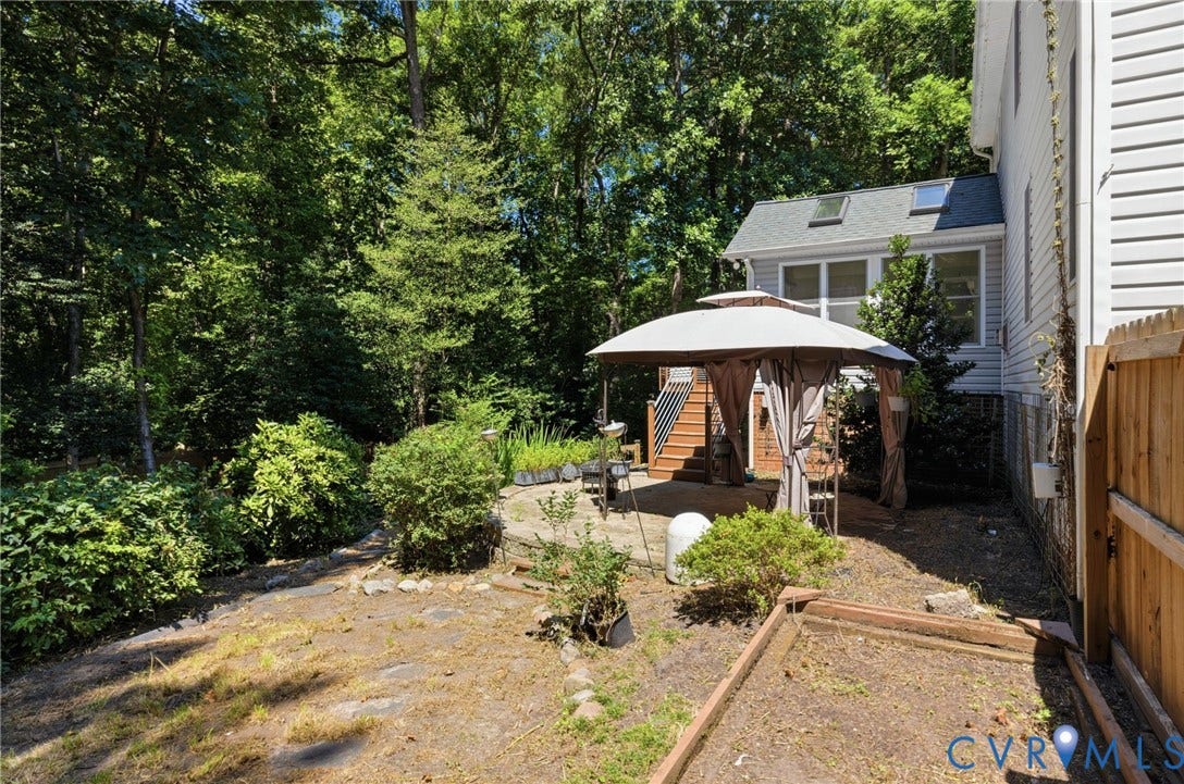5215 Lippingham Lane, Stoney Glen West, Chester, VA 23831 Backyard featuring a stone patio with a gazebo, mature trees, and privacy fencing