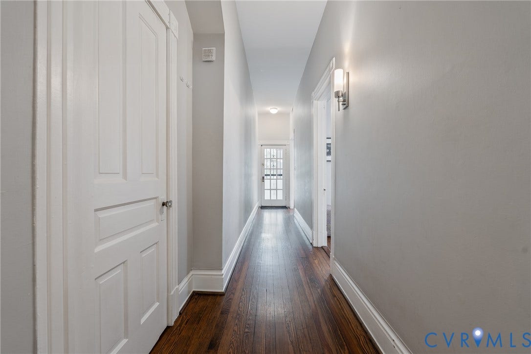 2016 Princess Anne Avenue, Union Hill, Richmond, VA 23223 Hallway with rich wood-finish flooring, light grey painted walls, white trim, and a contemporary wall sconce