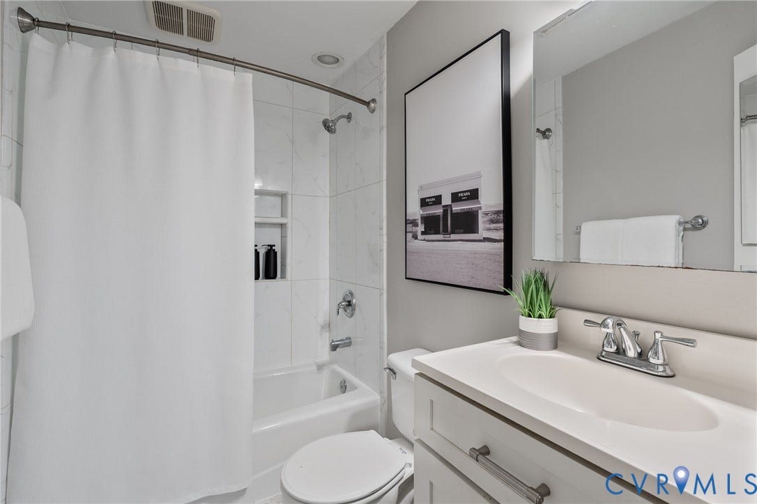 2016 Princess Anne Avenue, Union Hill, Richmond, VA 23223 Bathroom featuring a vanity with an integrated sink, polished chrome faucet, and a wall-mounted mirror