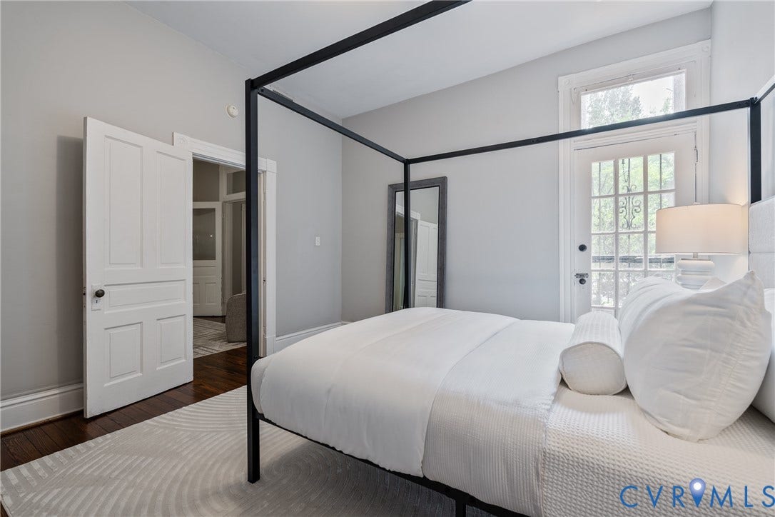 2016 Princess Anne Avenue, Union Hill, Richmond, VA 23223 Room featuring hardwood flooring, light gray walls, a white paneled door, and a glass-paned exterior door with transom window