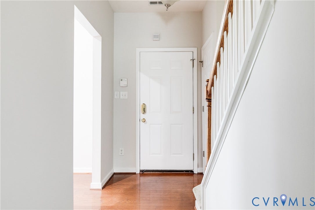 8004 Creekside Village Drive, Creekside Village, Mechanicsville, VA 23111 Entryway featuring a paneled door, wood-finish flooring, and a staircase with white risers and a wood handrail