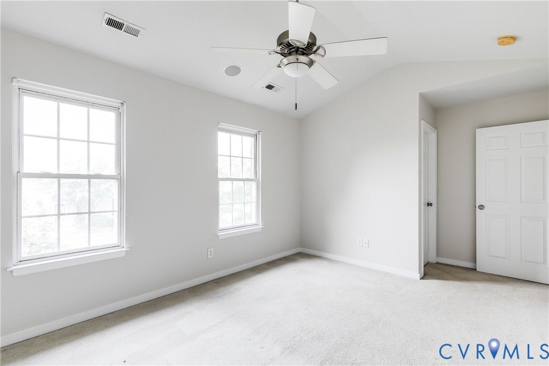8004 Creekside Village Drive, Creekside Village, Mechanicsville, VA 23111 Light-filled room featuring two double-hung windows, a vaulted ceiling, and a ceiling fan with integrated lighting