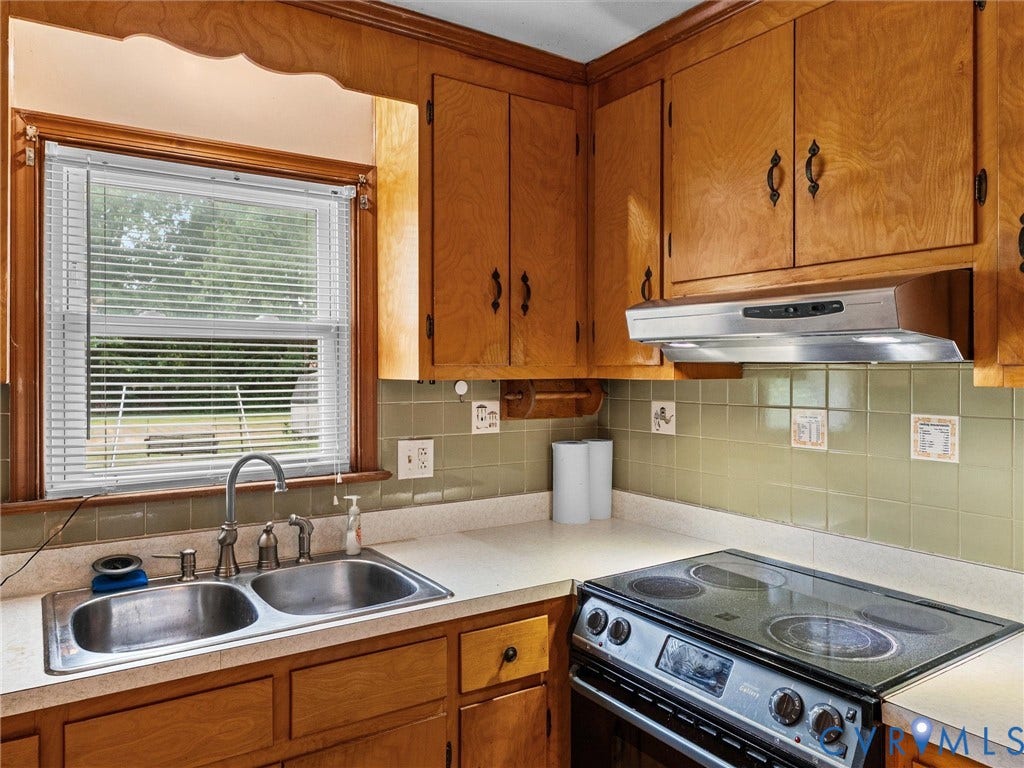 9633 Shamrock Drive, Centralia Gardens/Salem Woods, Chesterfield, VA 23237 Kitchen featuring wood cabinetry, a double basin stainless steel sink, a modern electric range, and a tiled backsplash