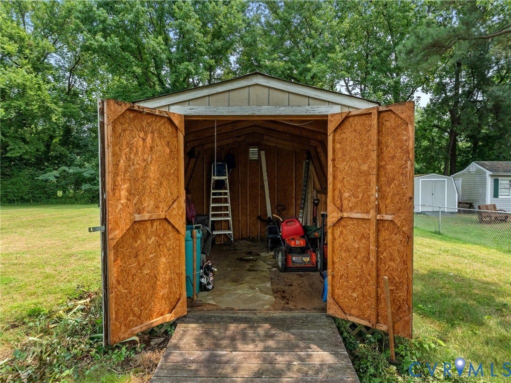 9633 Shamrock Drive, Centralia Gardens/Salem Woods, Chesterfield, VA 23237 Freestanding storage shed featuring wide double doors, a sloped roofline, and a wooden ramp