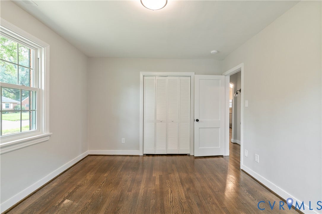 3512 Fendall Avenue, Edgewood, Richmond, VA 23222 Interior space featuring wood-finish flooring, white trim, light-toned walls, and a window with outdoor tree scenery