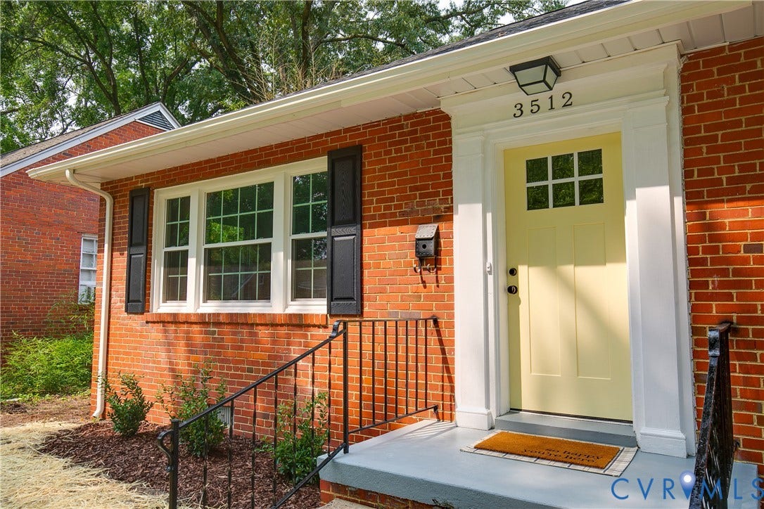 3512 Fendall Avenue, Edgewood, Richmond, VA 23222 Brick facade entry featuring a light-colored door with upper window panes, white trim, and a black outdoor light fixture