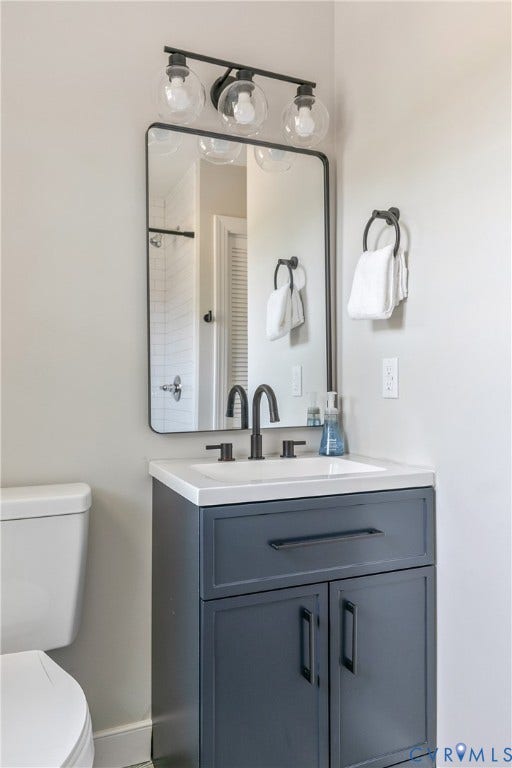 3512 Fendall Avenue, Edgewood, Richmond, VA 23222 Bathroom vanity with a white countertop and integrated sink, matte black faucet, and a rectangular mirror with a black frame