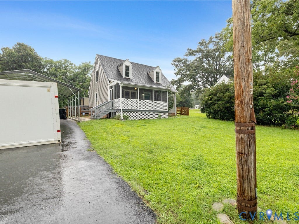 12230 Harrowgate Road, Chesterfield, VA 23831 Gable-roof property featuring dormer windows, a covered front porch with lattice detailing, and a spacious green lawn