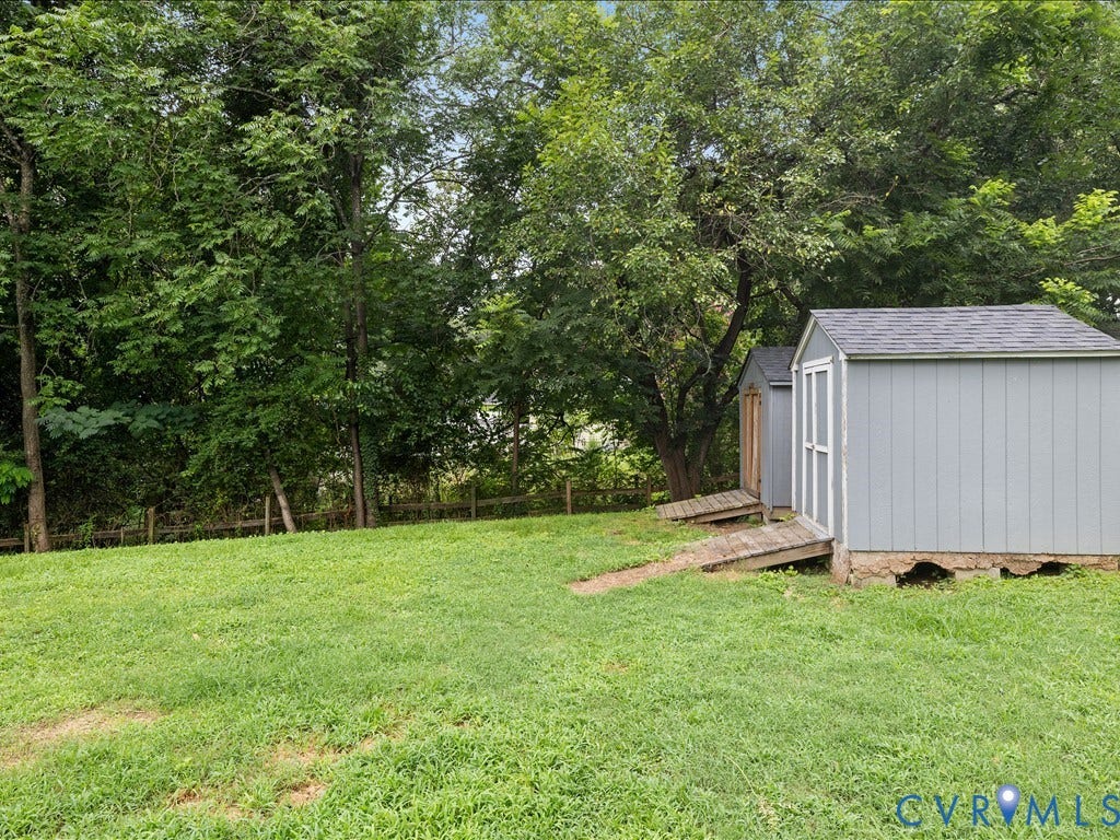 12230 Harrowgate Road, Chesterfield, VA 23831 Spacious backyard with two storage sheds featuring light blue siding and dark shingle roofs