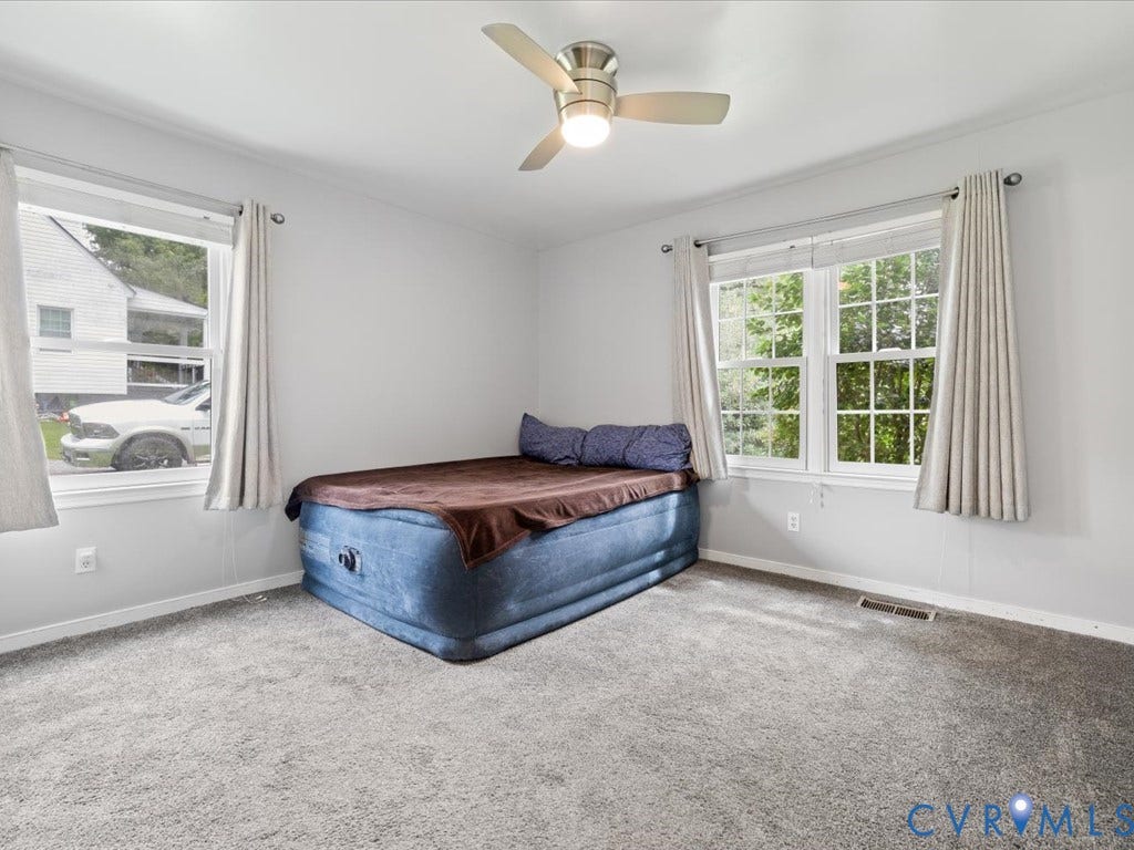 12230 Harrowgate Road, Chesterfield, VA 23831 Light gray wall paint with white trim, gray carpeting, a ceiling fan with integrated lighting, and multiple windows