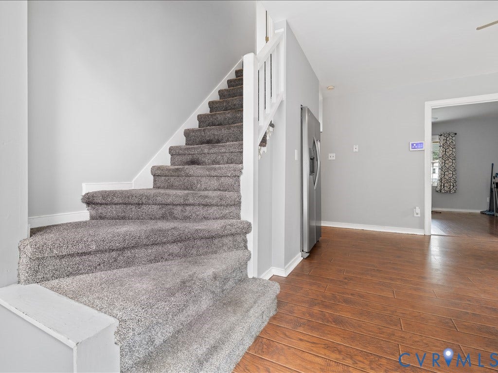 12230 Harrowgate Road, Chesterfield, VA 23831 Carpeted staircase with white trim, wood-finish flooring, and a stainless steel refrigerator