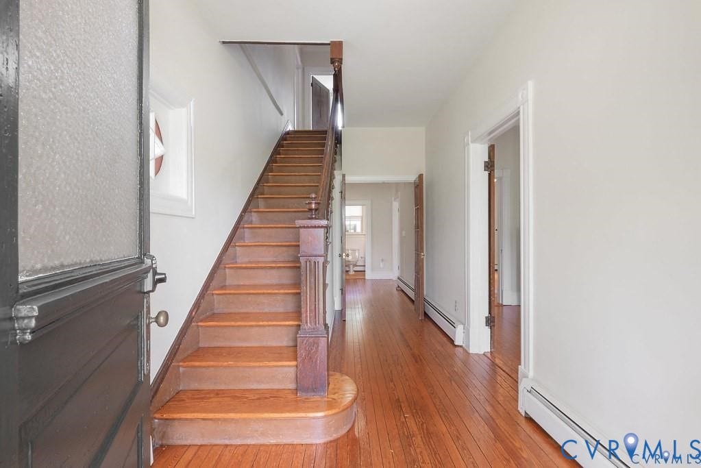 11300 Aspen Grove Drive, Glen Allen, VA 23059 Entryway featuring a wood staircase, wood-finish flooring, white baseboards, and a dark-paneled front door with a textured glass insert