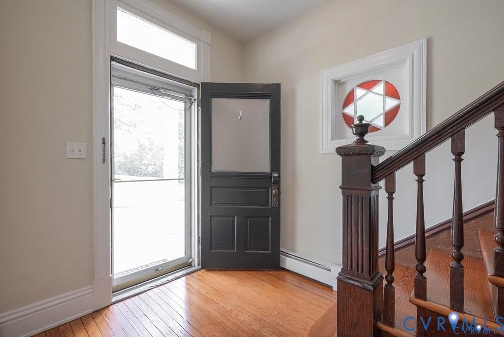 11300 Aspen Grove Drive, Glen Allen, VA 23059 Foyer featuring wood-finish flooring, a dark wood-finish staircase with turned balusters, and a decorative stained-glass window