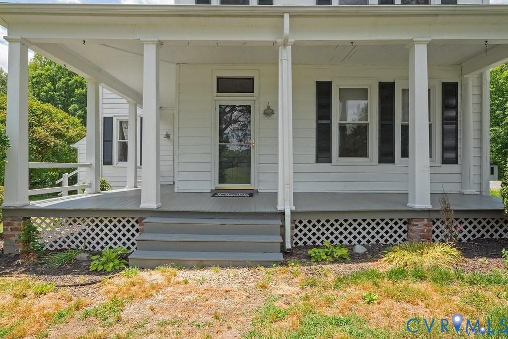11300 Aspen Grove Drive, Glen Allen, VA 23059 Inviting front porch featuring a multi-pane glass door, dark louvered shutters, white siding, and a lattice foundation skirt