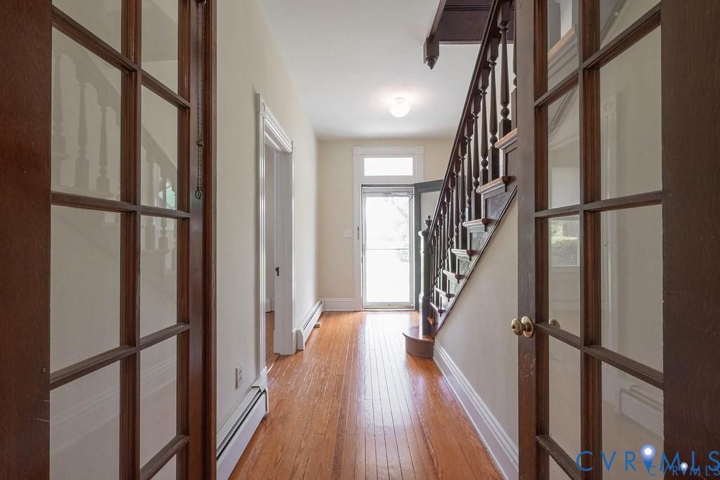 11300 Aspen Grove Drive, Glen Allen, VA 23059 Entryway featuring wood-finish flooring, a traditional wooden staircase with balusters, and a glass-paneled interior door