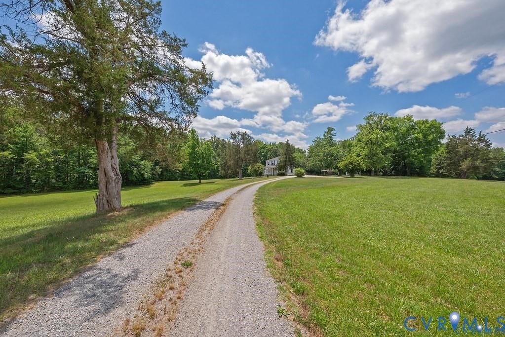 11300 Aspen Grove Drive, Glen Allen, VA 23059 Gravel driveway leading to a white residence with dark shutters