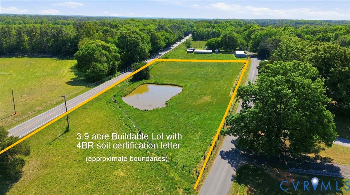 Expansive 3.9-acre buildable lot with established boundaries, featuring mature trees and a natural pond