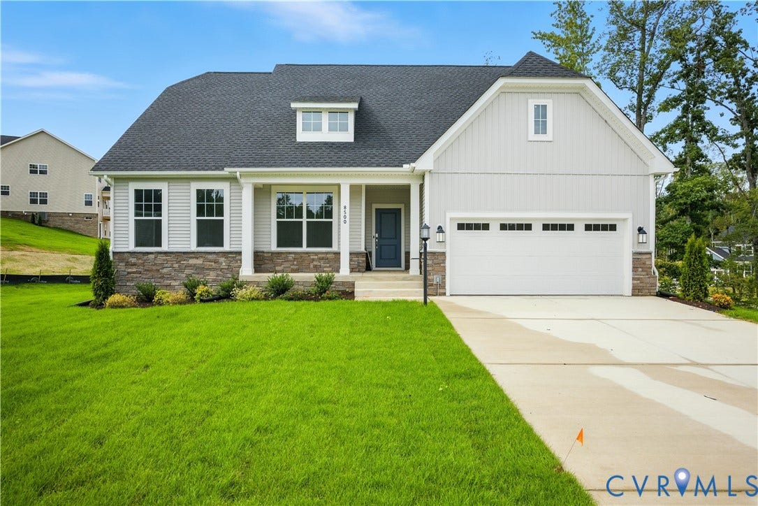 Contemporary single-story residence with a light gray siding exterior, stone veneer accents, and a dark asphalt shingle roof