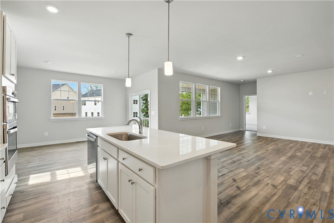 Kitchen island featuring a stainless steel sink, chrome faucet, and integrated dishwasher