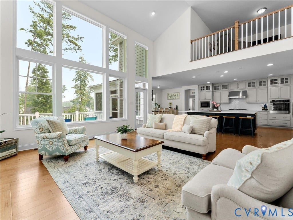 6642 Stonewolf Court, Moseley, VA 23120 Great room featuring a two-story ceiling, expansive floor-to-ceiling windows, and hardwood flooring