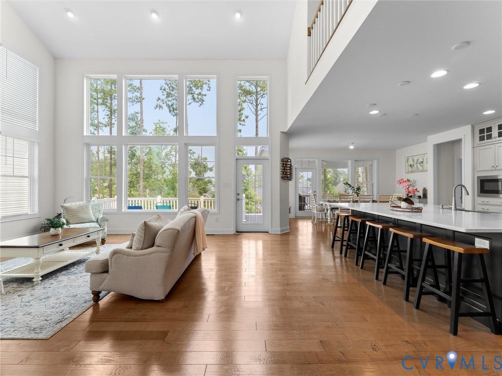 6642 Stonewolf Court, Moseley, VA 23120 Open-concept living space featuring high ceilings and expansive windows