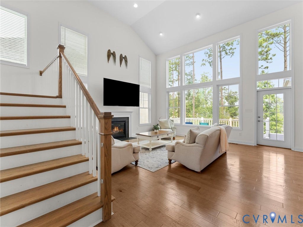 6642 Stonewolf Court, Moseley, VA 23120 Two-story living area featuring extensive window treatments, a fireplace with a mantel, and hardwood flooring