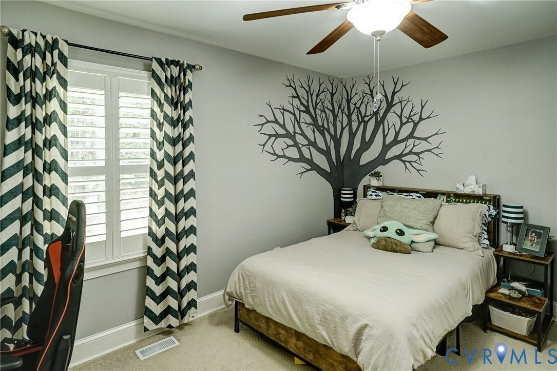 1174 Dorset Road, Powhatan, VA 23139 Light-filled room featuring a ceiling fan, wall-mounted tree decal, a window with plantation shutters, and carpeted flooring