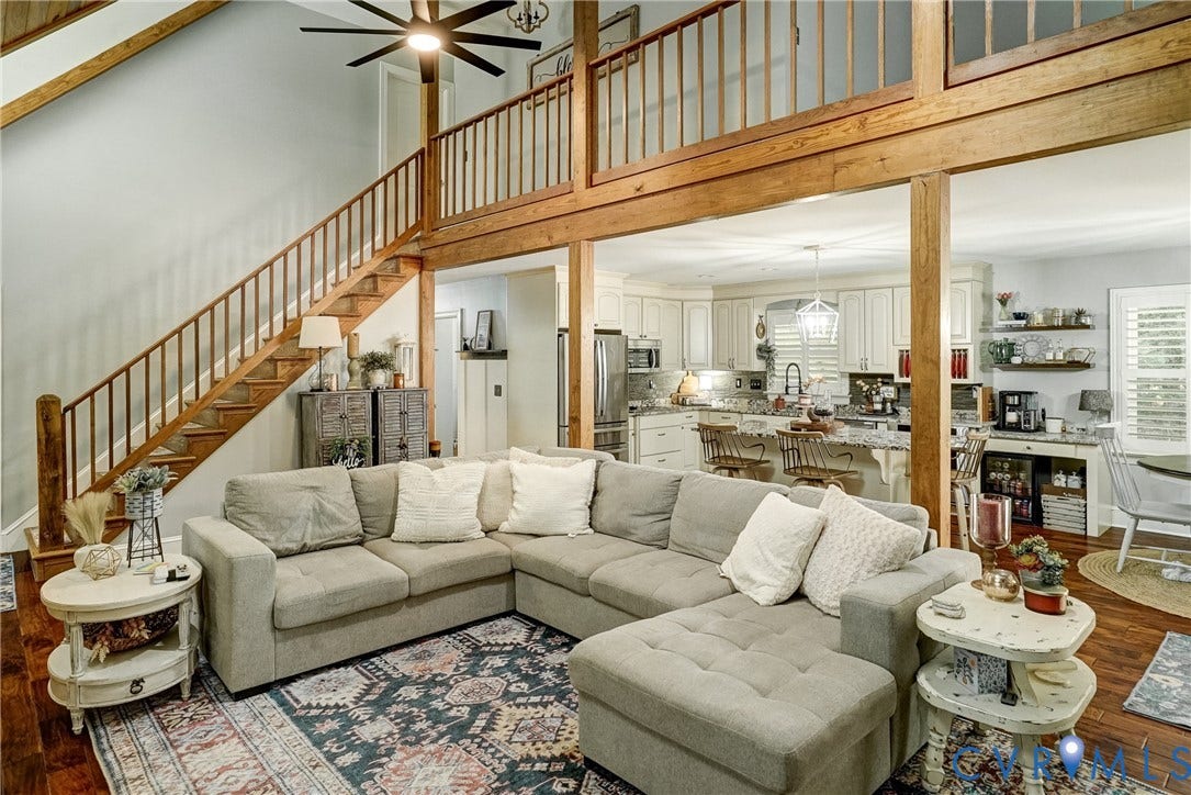 1174 Dorset Road, Powhatan, VA 23139 Spacious living area featuring a two-story ceiling, exposed wood beams, and a wood staircase with balusters