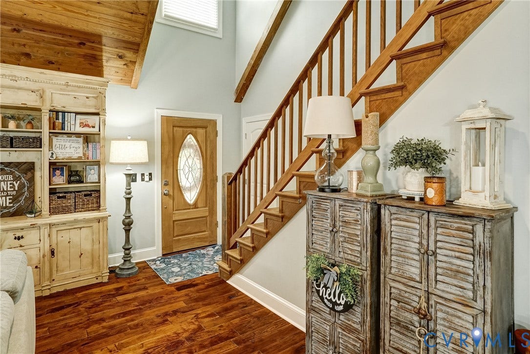 1174 Dorset Road, Powhatan, VA 23139 Entryway featuring wood-finish flooring, a solid wood entry door with an oval leaded glass insert, and a natural wood staircase with balusters