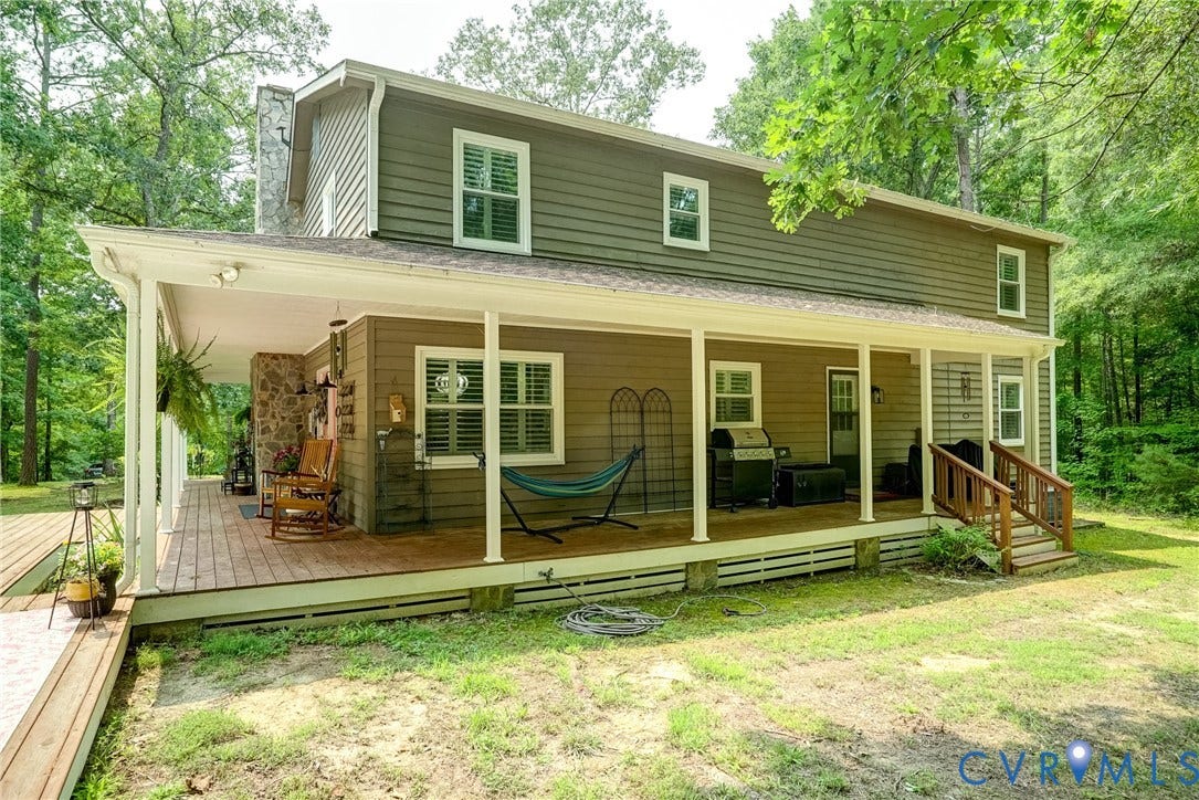 1174 Dorset Road, Powhatan, VA 23139 Two-story residence featuring horizontal siding, a full-length covered porch with white columns, and a stone chimney