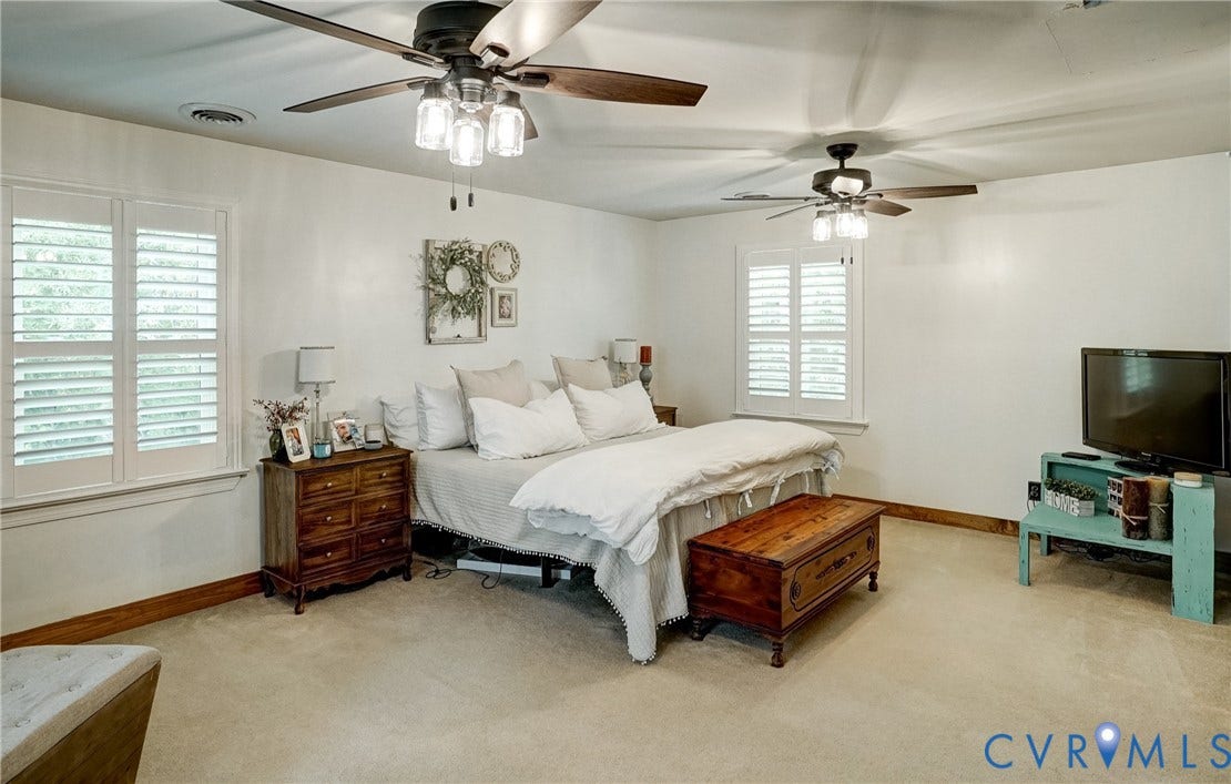 1174 Dorset Road, Powhatan, VA 23139 Spacious room featuring two ceiling fans with integrated lighting, multiple windows with white plantation shutters, white walls, and carpeted flooring
